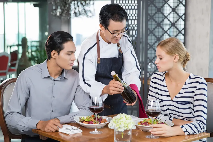 asian-waiter-offering-red-wine-young-couple_1262-1429.jpg